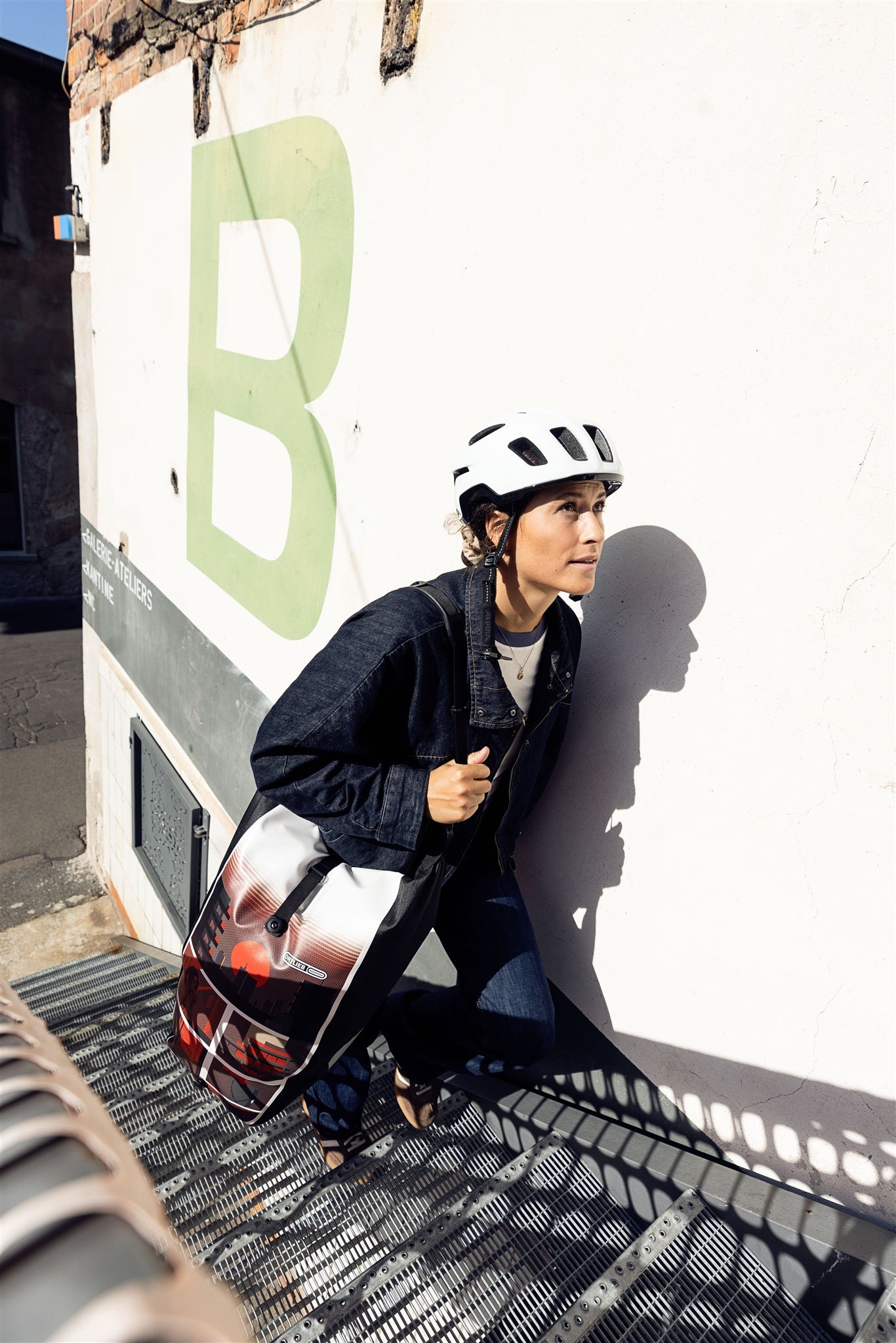 Bicicleta con bolso ORTLIEB Back-Roller Design color design "Morning Routine" apoyada en pared clara