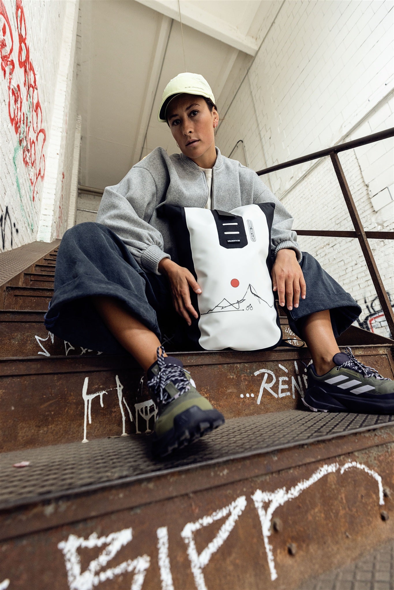 Persona andando en bicicleta en entorno urbano con mochila ORTLIEB Velocity Design blanca y negra